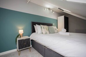 A bedroom with a bed, bedside table, and a nightstand.