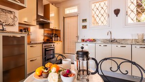 A modern kitchen with a stove, oven, and coffee maker on the counter. - ROMANTIC VILLA VI4412 By Riviera Holiday Homes (Villefranche-sur-Mer)