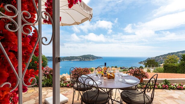 An outdoor patio with a table set for dining, overlooking a coastal view. - ROMANTIC VILLA VI4412 By Riviera Holiday Homes (Villefranche-sur-Mer)