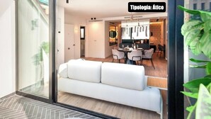 Ein modernes Interieur mit einem weißen Sofa, einer Essecke und einer Küche.