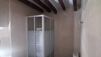 Een badkamer met een douchecabine, een wastafel en een toilet met douchefunctie.