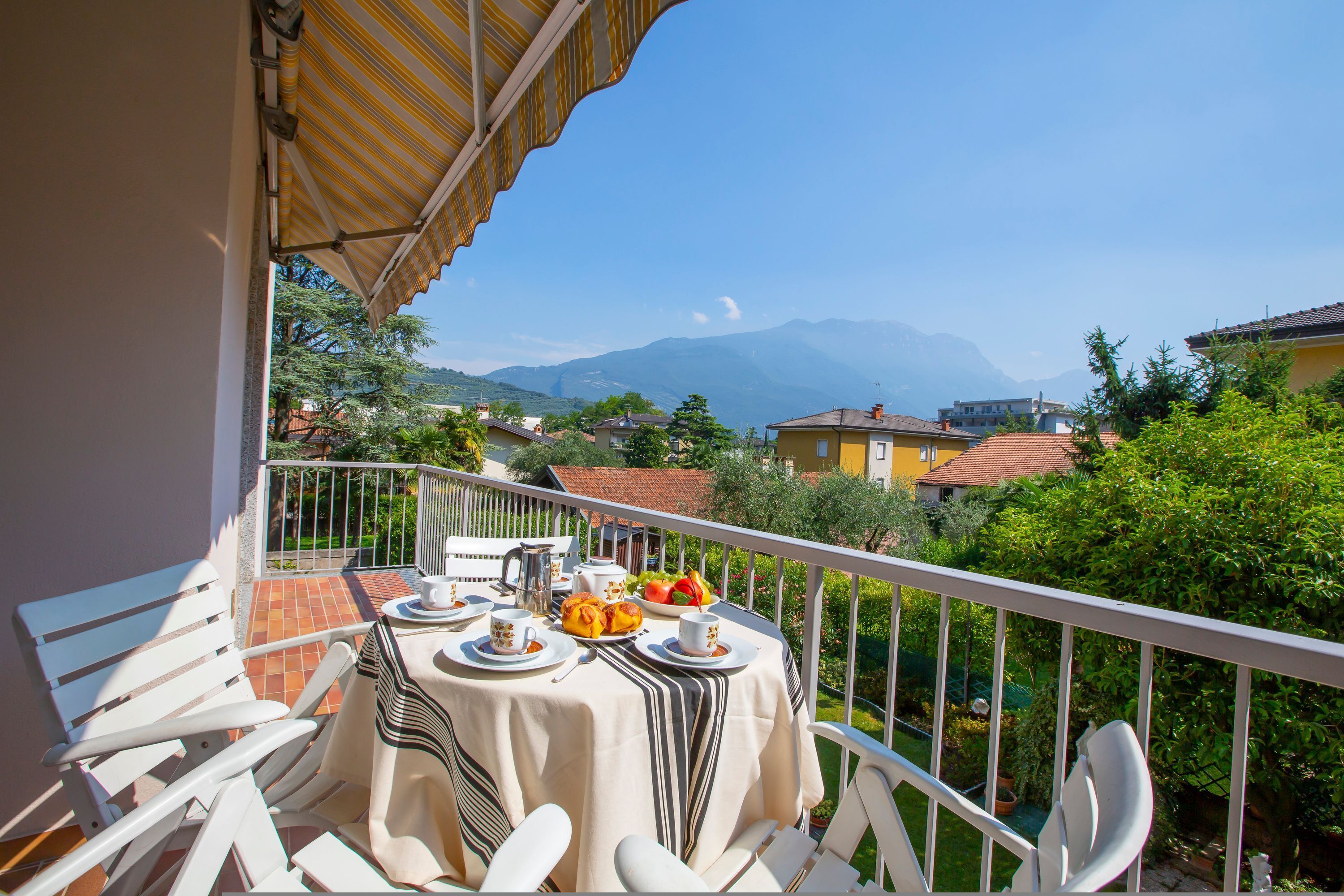 Ein Balkon mit Frühstückstisch, mit Blick auf eine Berglandschaft.
