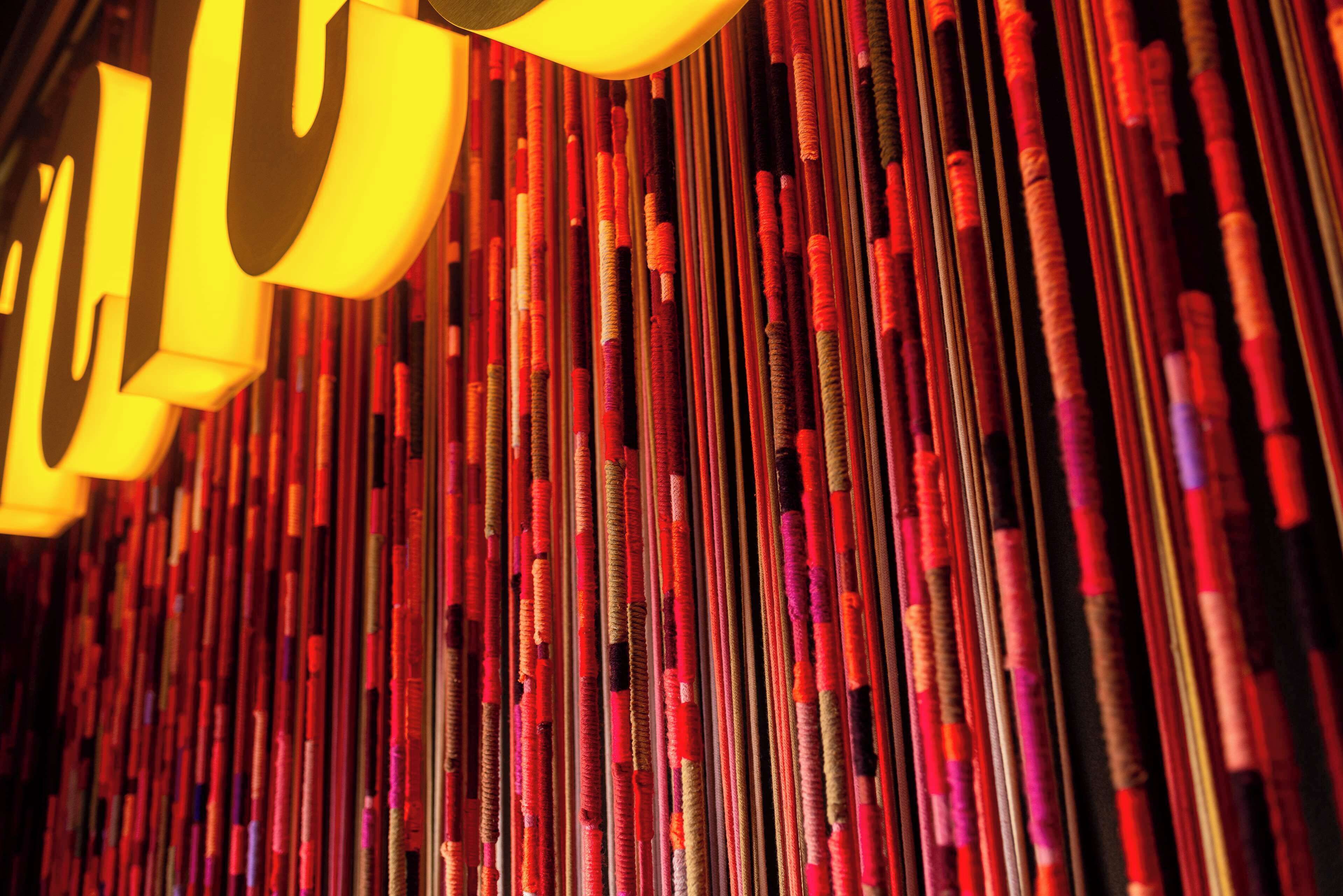 A close-up of vertical, colorful, textured elements, possibly part of a decorative installation or wall.