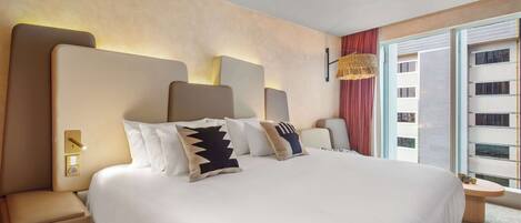 A modern hotel room with a large bed, a bedside table, a nightstand, and a large window with a view of the city.