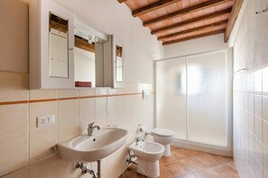 Bathroom features a large mirror, sink, bidet, and toilet in a clean, minimalist design.
