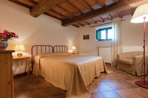 Relax in this serene bedroom with a large bed, wooden ceiling, and a window offering a view of the outside.