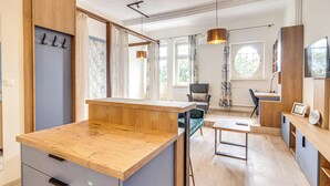 Una cocina moderna con encimeras de madera, un lavaplatos empotrado y un comedor con mesa y sillas.
