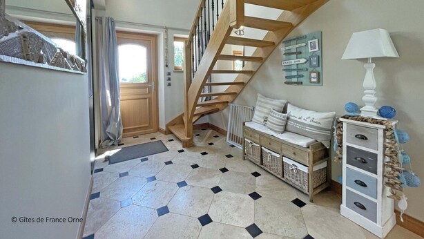 A staircase with wooden railings leading to an upper floor, a bench with cushions, a wall-mounted lamp, and a tiled floor with a geometric pattern. - Country House with Garden and Spa for 14 in Les Ventes-de-Bourse (Les Ventes-de-Bourse)