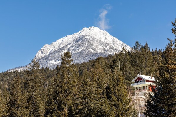 Ein schneebedeckter Berg mit einer Hütte am Hang.