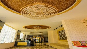 A reception area with a chandelier, marble flooring, and a reception desk. - Hotel Eagle Inn (Udaipur)
