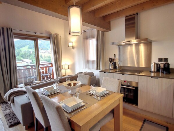 Una cocina moderna con comedor, vigas de madera y vistas al exterior.