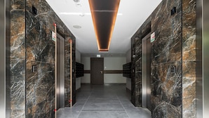 A modern elevator lobby with marble walls and a tiled floor. - RentPlanet - Apartament Pileckiego (Warsaw)