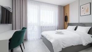 A modern hotel room with a bed, a desk, and a chair. - RentPlanet - Apartament Pileckiego (Warsaw)