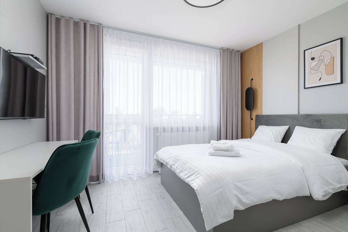 Ein modernes Hotelzimmer mit Bett, Schreibtisch und Stuhl.