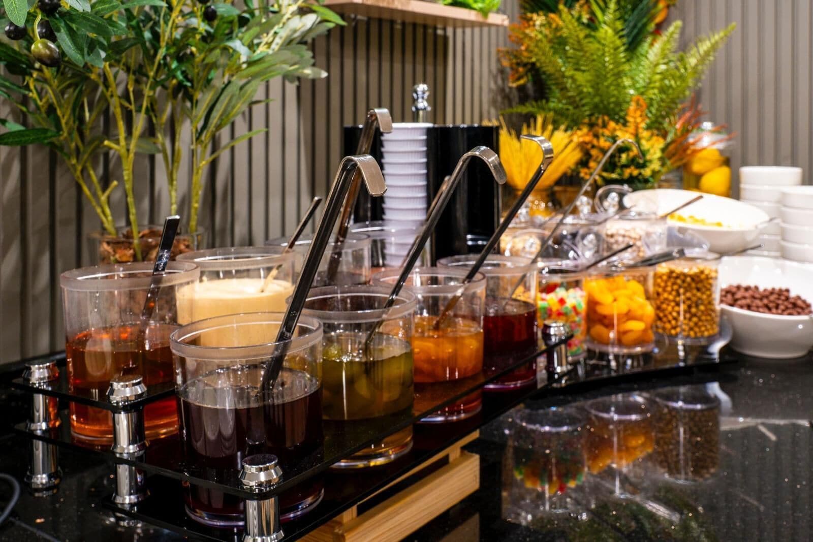 Disposição de buffet com diversas bebidas e alimentos.