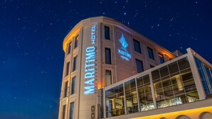 Un bâtiment d’angle sur lequel on peut voir l’enseigne de l’hôtel Maritim, avec un ciel étoilé en arrière-plan.