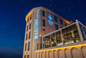 Un edificio en esquina con el letrero del Hotel Maritim y un cielo estrellado.