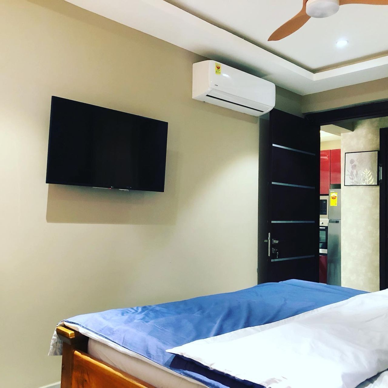 Une chambre d’hôtel équipée d’un lit, d’un téléviseur à écran plat fixé au mur et d’un appareil de climatisation.