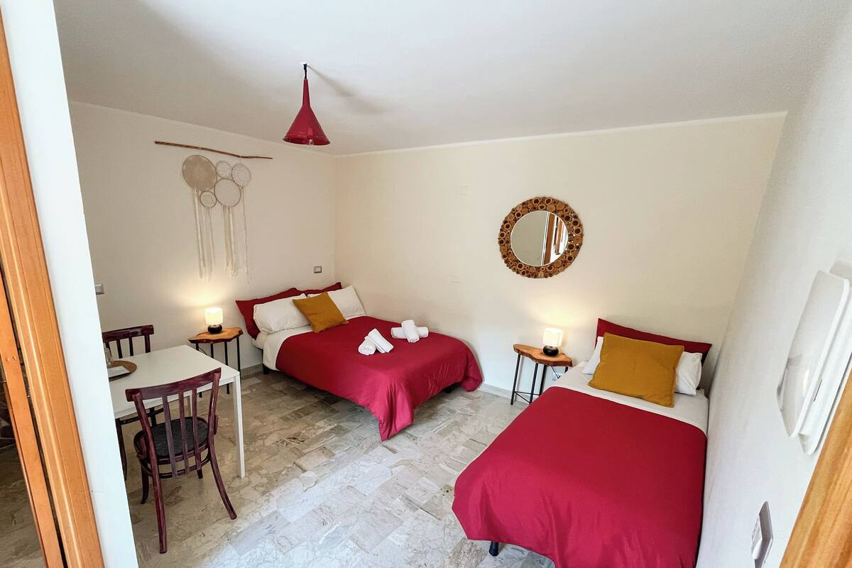 Une chambre avec deux lits, une petite table et une chaise.