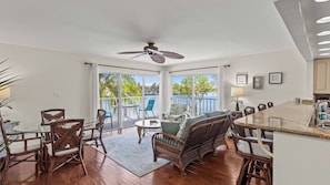 A spacious room with a dining area, a sofa, and a view of the outdoors. - Kokomo on Coco Plum at the Bonefish Yacht Club with 2 Boat Slips, Pool, Tennis/Pickle Ball Court, and Kayaks (Marathon)