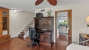 Un bureau à domicile équipé d’un bureau, d’une chaise et d’une imprimante.