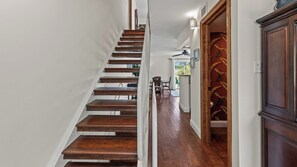 A wooden staircase leading to a room with a view of the outdoors.