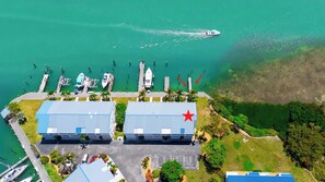 An aerial view of a marina with boats docked, a star symbol indicating a point of interest, and a clear view of the surrounding greenery.