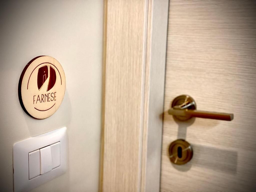 A door with a brass handle and a round, beige-colored sign with the word "FARINSE" on it.