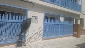Un edificio con un letrero que dice "LA MAISON DEL MAR" y una valla metálica decorativa.