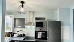 A modern kitchen with stainless steel appliances, a built-in oven, and a microwave. - Entire rental unit in Maisons-Alfort, France (Maisons-Alfort)