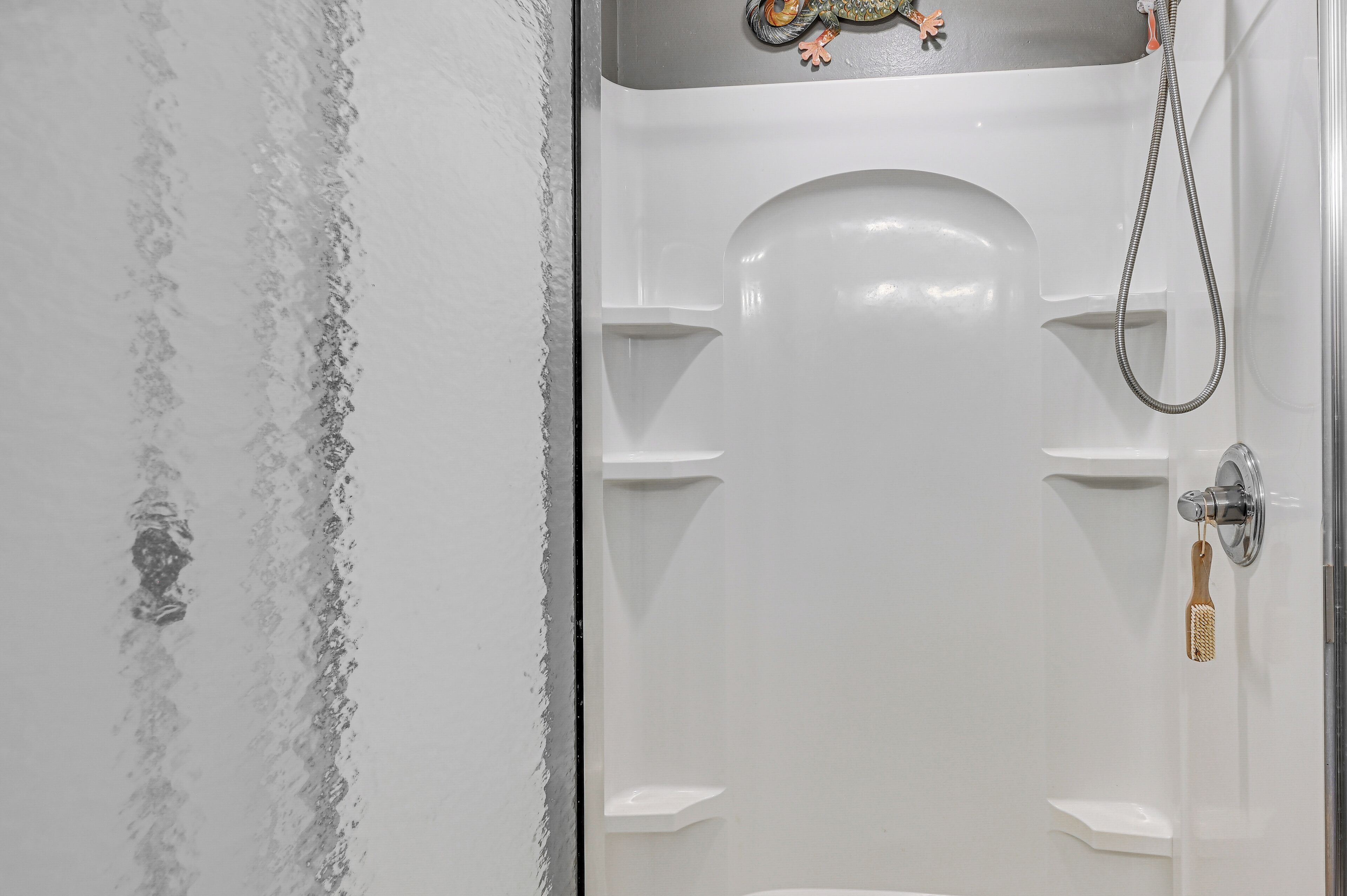 A white bathtub with a shower head and a towel rack.