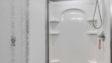 A white bathtub with a shower head and a towel rack.
