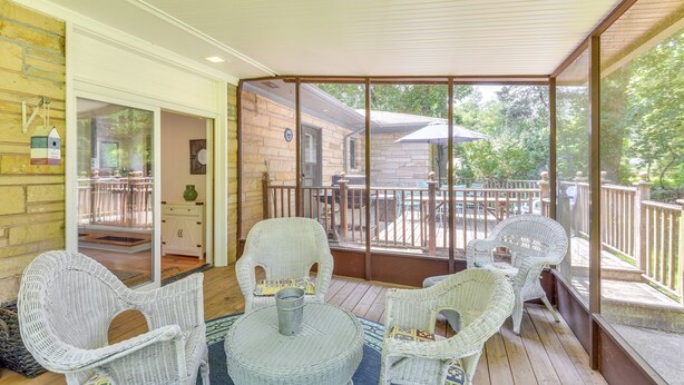 A covered porch with wicker furniture and a view of a house. - Charming Union Pier Home w/ Deck: Half-mi to Beach (Union Pier)