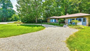 A house with a gravel driveway, a lawn, and trees in the background. - Charming Union Pier Home w/ Deck: Half-mi to Beach (Union Pier)