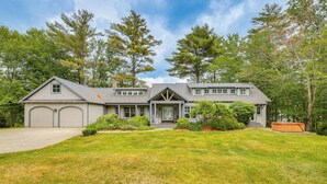 A two-story house with a garage, a front porch, and a well-maintained lawn. - Lakefront New London Retreat w/ Dock & Hot Tub! (New London)