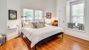 A bedroom with a bed, wooden flooring, white walls, two windows with blinds, and ceiling fans. - Charming Georgia Cottage ~ 19 Mi to Statesboro! (Metter)