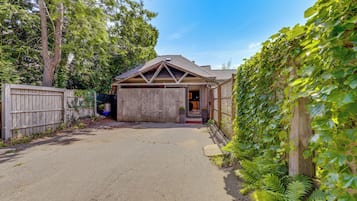 Stylish home with a garage, driveway, and lush green surroundings.