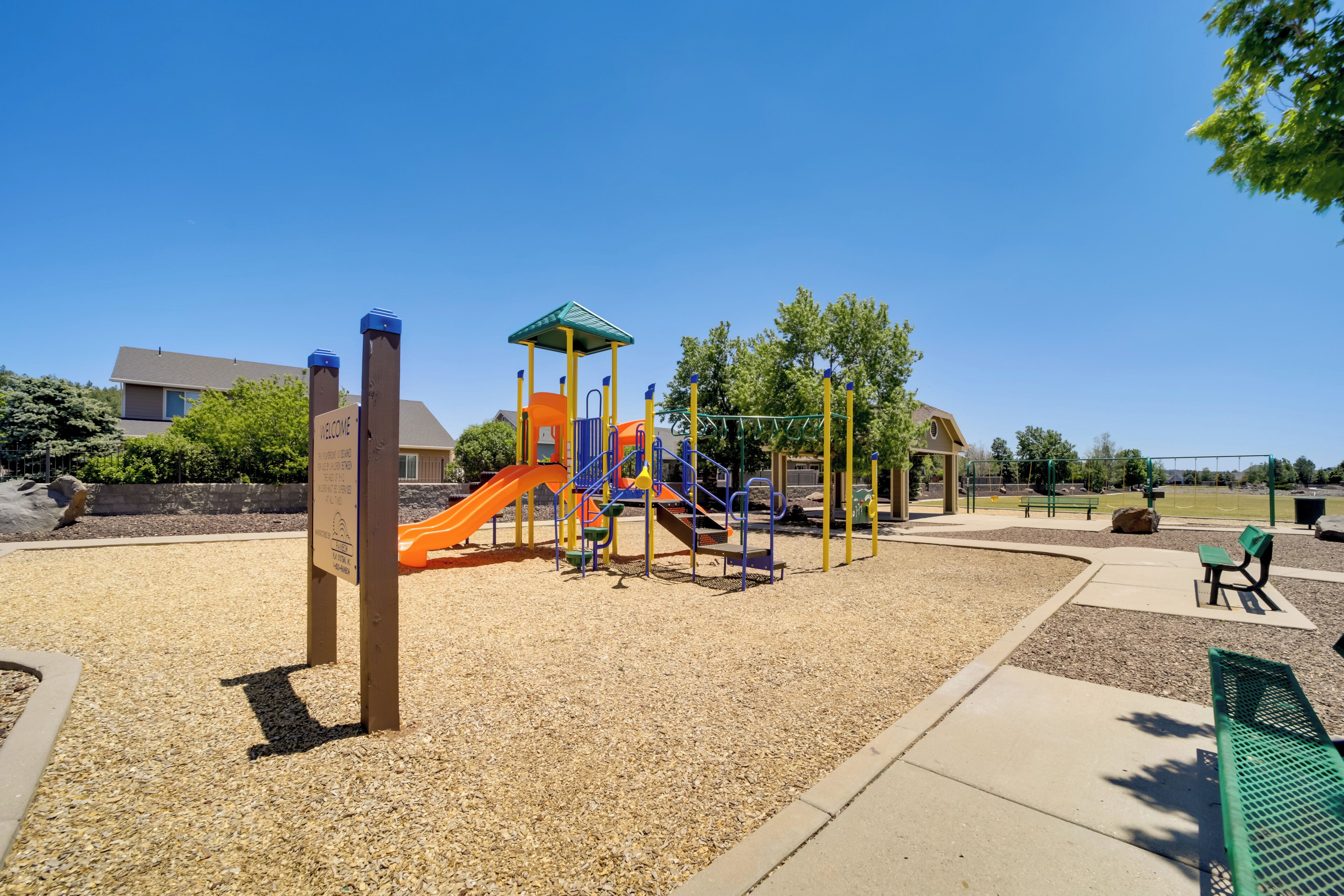Un parque infantil con tobogán, estructuras para escalar y una zona de juegos cubierta.