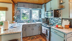 A kitchen with granite countertops, stainless steel appliances, and light blue cabinets. - Group Retreat on Wolf Lake! Paddle, Fish & BBQ (Jackson)