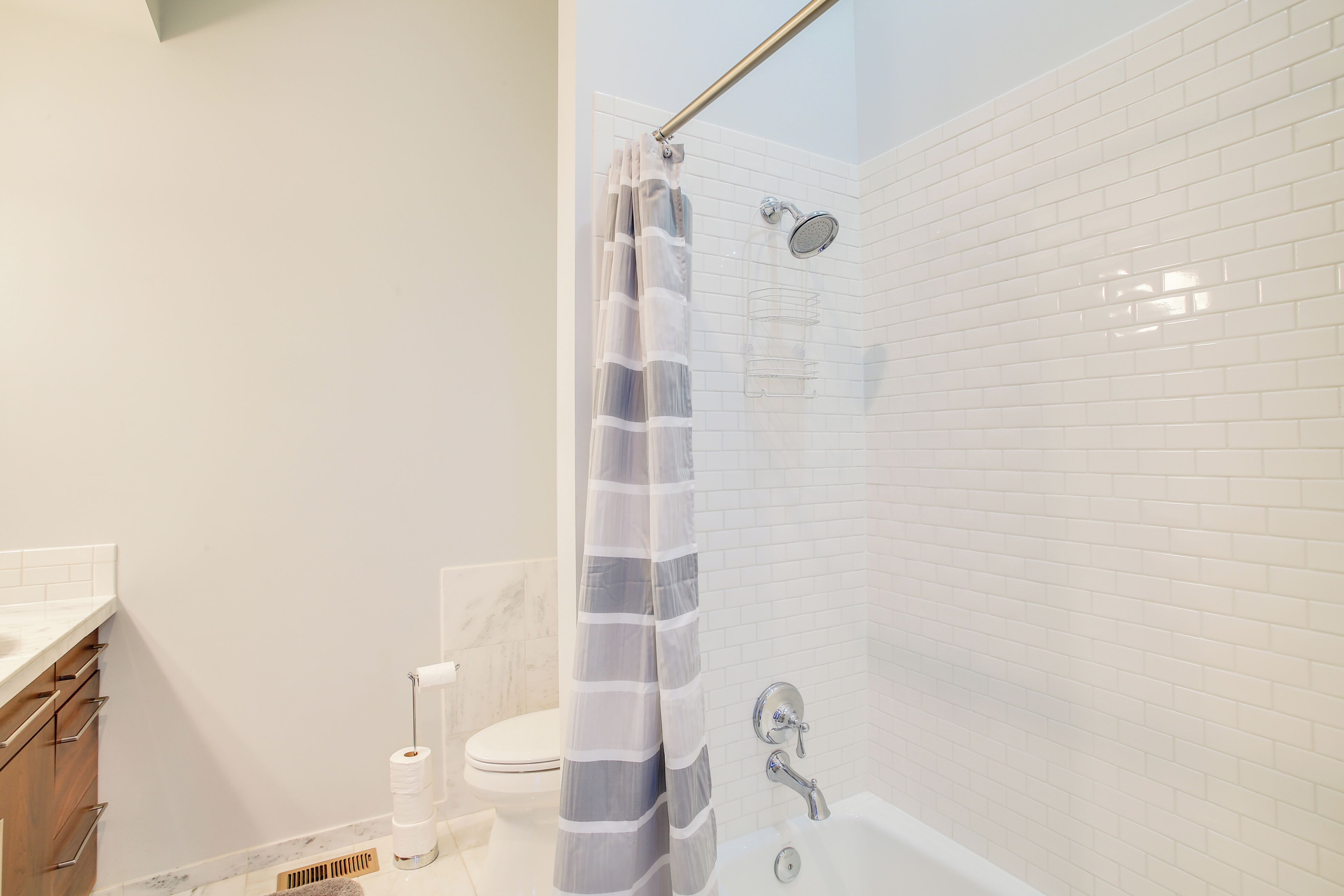 A modern bathroom with a glass shower enclosure, a white toilet, and a bathtub.