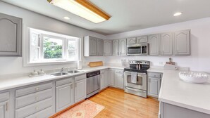 Una cocina con armarios grises, lavavajillas, horno y microondas.