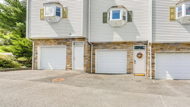 A two-story building with a garage entrance, stone foundation, and a brick lower level. - Chic Morgantown Vacation Rental - 2 Mi to Wvu! (Morgantown)