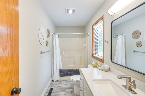 A bathroom with a shower, toilet, and sink.