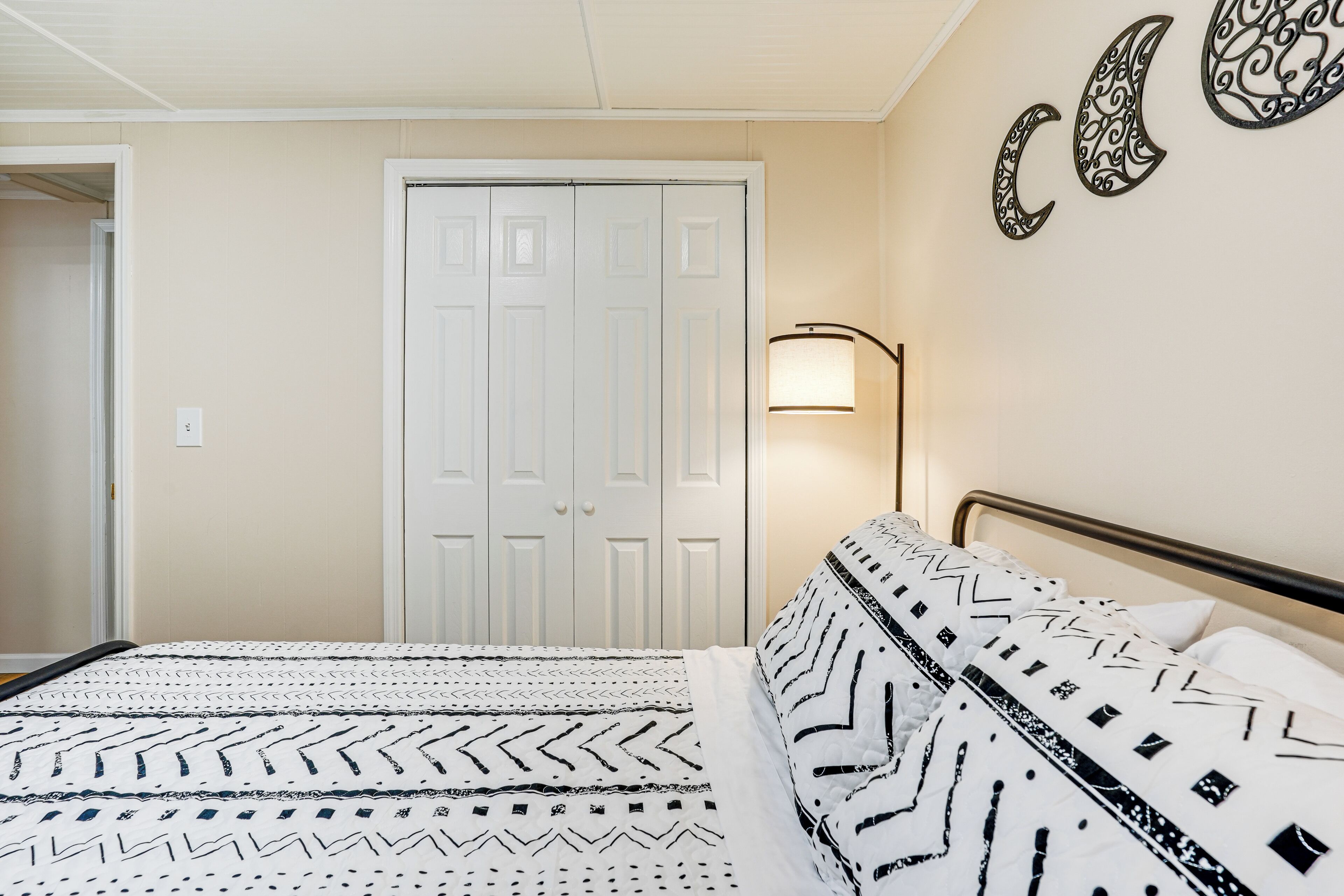 Une chambre à coucher avec un lit, une armoire et une lampe fixée au mur.
