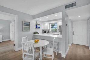 A modern kitchen with white cabinets, a white countertop, and a window. - F-237 - Deluxe Condo - Amazing Views and Sleeps 6 (Naples)