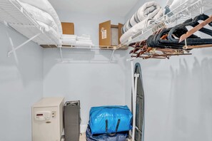 Ein Hotelzimmer mit Bett, Schrank, Schreibtisch und Mülleimer.