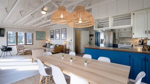 Een moderne keuken met witte kasten, een blauw aanrecht en een roestvrijstalen koelkast.