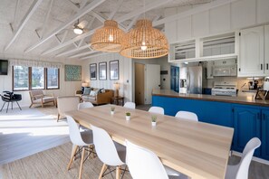 Una cocina moderna con armarios blancos, una encimera azul y un refrigerador de acero inoxidable.