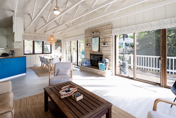A spacious living area with a fireplace, a dining area, and a kitchen with a blue accent wall.