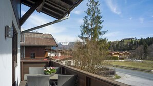 Un balcone con mobili in vimini e vista su una montagna.